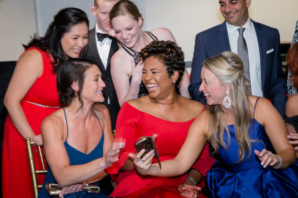 An image of women at a corporate event sharing a laugh with a cell phone photographed by Atlanta Commercial Photographer Karen Images