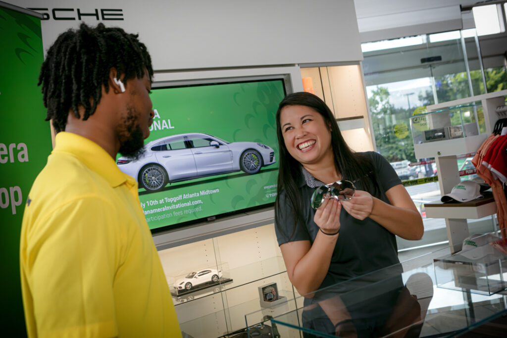 An image of people at a Top Golf gift shop during a corporate event sponsored by Porsche photographed by Atlanta Commercial Photographer Karen Images