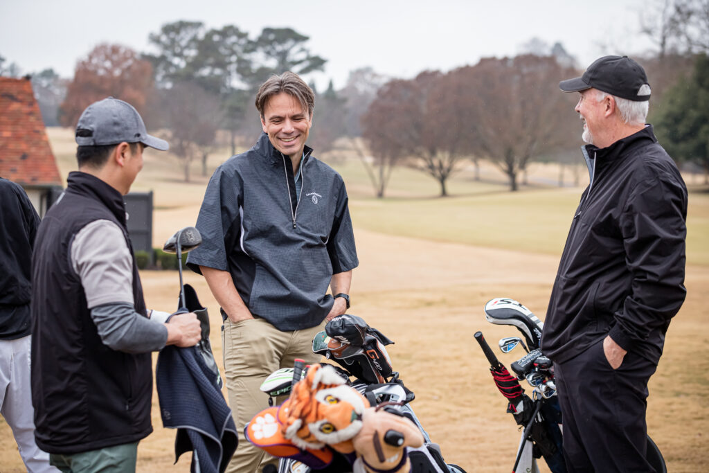 An image of golfers chatting on a driving range at a corporate event photographed by Atlanta Corporate Event Photographer Karen Images