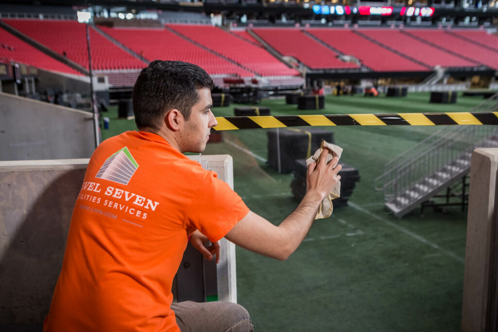 A man from Level 7 Facilities Services cleans Mercedes Benz Stadium