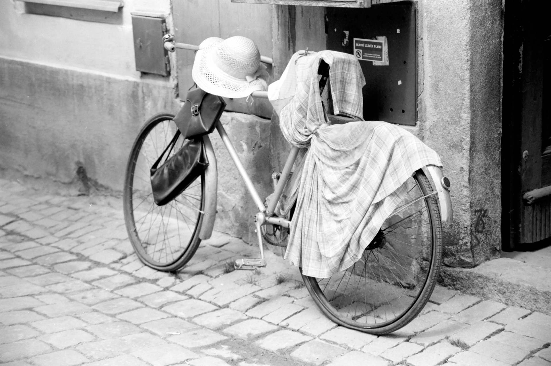 Bicycle draped with clothing outside a secondhand shop in Český Krumlov, Czech Republic