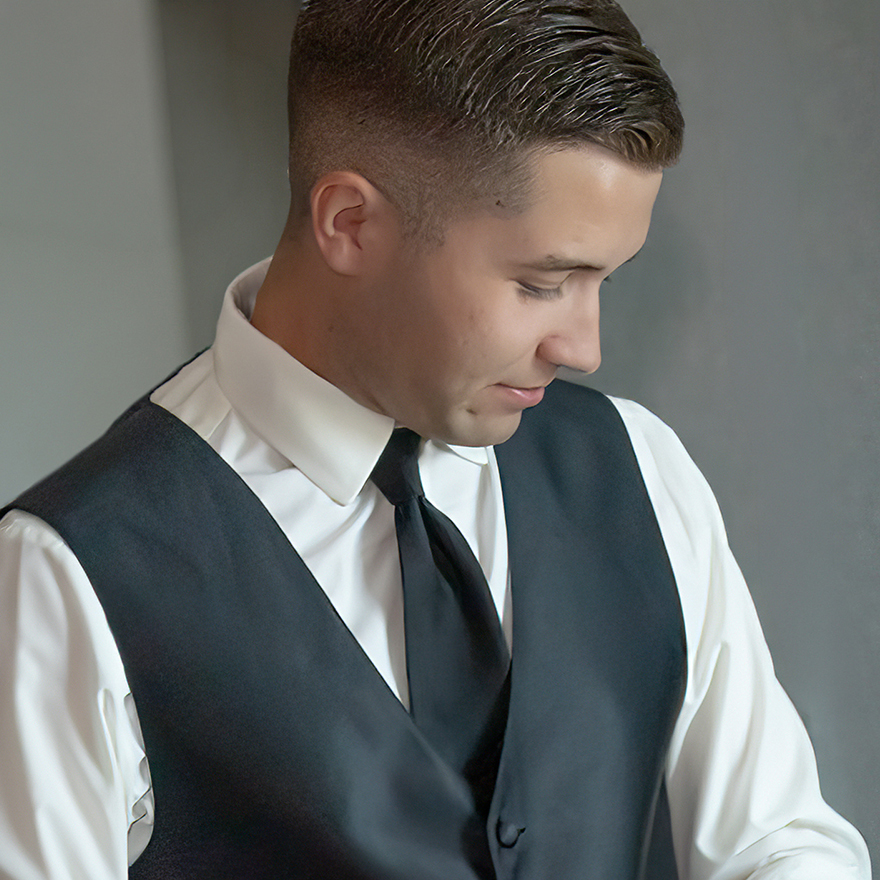 Groom adjusting his tie while getting ready for his wedding
