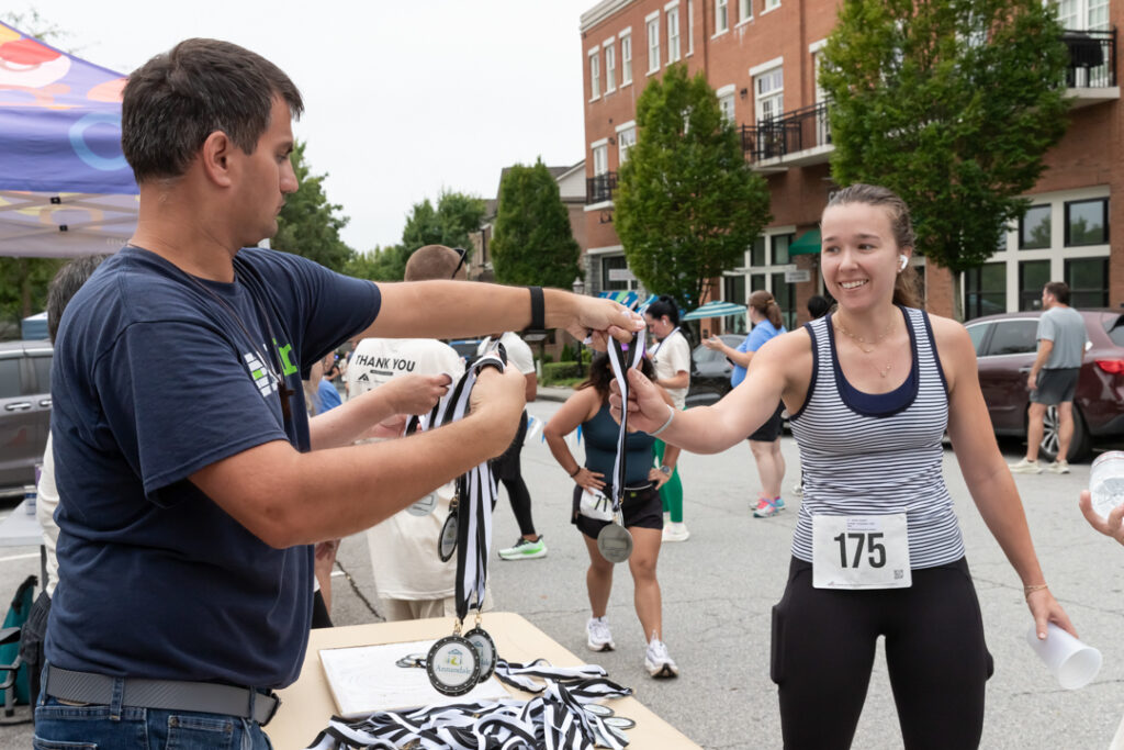 Participant celebrating at the finish of Annandale Village’s Extra Mile 5K