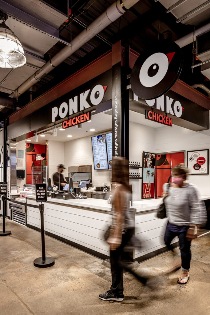 A Ponko Chicken restaurant in a food mall in Marietta Georgia with a motion blur of people walking