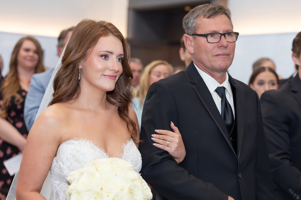 Bride walking with her father during the wedding ceremony at Limestone Hall in Lexington, Kentucky