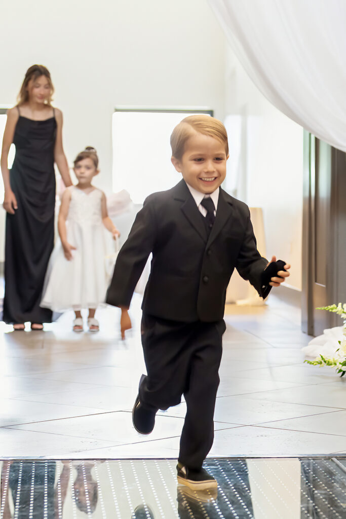 Ring bearer running down the aisle during the wedding ceremony in Lexington, Kentucky